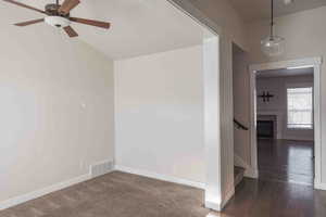 Unfurnished room with ceiling fan and dark hardwood / wood-style flooring