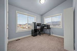 Carpeted office featuring vaulted ceiling