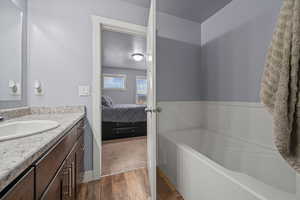 Bathroom featuring vanity, LVP Flooring, a textured ceiling, and a tub to relax in