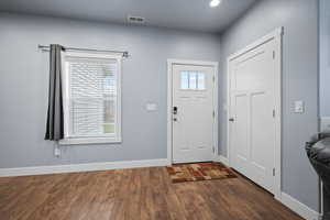 Foyer entrance with dark wood-type flooring and a wealth of natural light