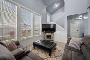 Carpeted living room with a high vaulted ceiling