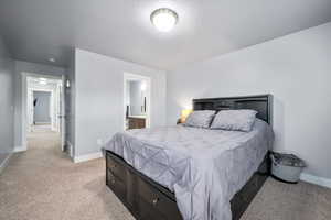 Carpeted bedroom featuring ensuite bath