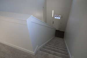 Staircase featuring carpet flooring