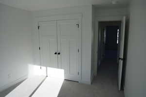 Carpeted bedroom with a closet