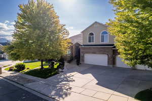 View of property hidden behind natural elements featuring a garage