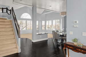 Dining space with lofted ceiling, dark wood-type flooring, and a wealth of natural light