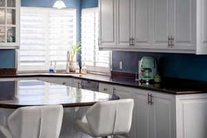 Kitchen featuring white cabinets, dishwasher, and sink