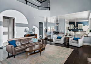 Living room with a high ceiling and dark wood-type flooring