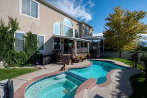 View of pool with a pergola, a wooden deck, and an in ground hot tub