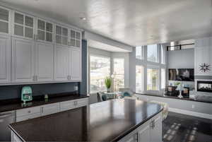 Kitchen with dark hardwood / wood-style flooring, white cabinets, and stainless steel dishwasher