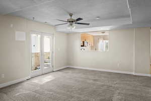 Spare room featuring a textured ceiling, light colored carpet, and ceiling fan