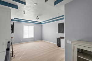 Unfurnished living room featuring a textured ceiling, light carpet, and a tray ceiling