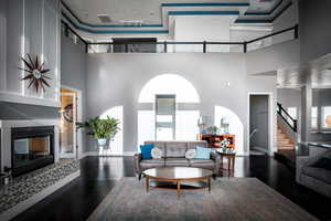 Living room with dark wood-type flooring and a high ceiling