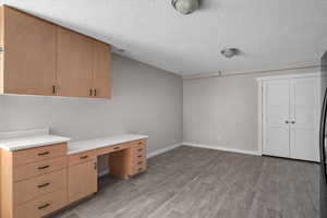 Unfurnished office featuring a textured ceiling and light hardwood / wood-style floors