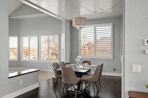 Dining space featuring a textured ceiling, wood-type flooring, and lofted ceiling