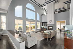 Living room featuring dark hardwood / wood-style flooring, a multi sided fireplace, and high vaulted ceiling