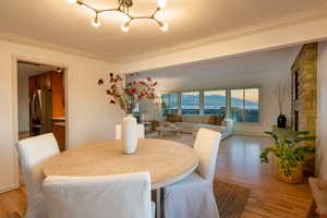 Dining space with a mountain view, crown molding, and light hardwood / wood-style flooring