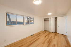 Unfurnished bedroom with light wood-type flooring and two closets