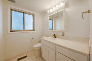 Bathroom with tile patterned flooring, vanity, and toilet