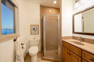 Bathroom with tile patterned flooring, vanity, toilet, and walk in shower