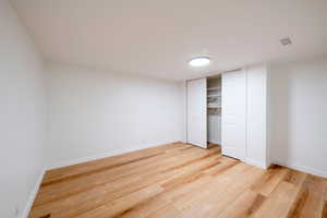 Unfurnished bedroom with a closet and hardwood / wood-style flooring