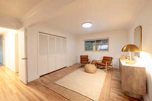 Sitting room with light hardwood / wood-style floors and crown molding