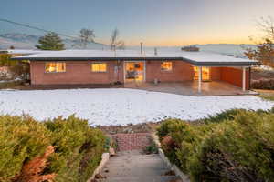 Snow covered house with a carport and a mountain view