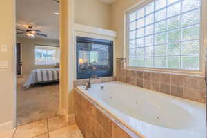 Primary bedroom leading into primary bath with a see through fireplace & jetted tub