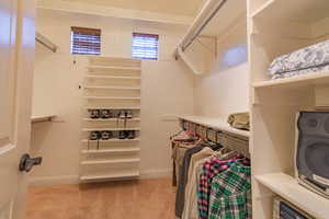 Primary bedroom with shoe racks, hanging rods, shelves & cubbies