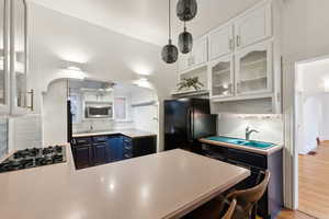 Kitchen featuring white cabinets, stainless steel appliances, blue cabinets, and light hardwood / wood-style floors