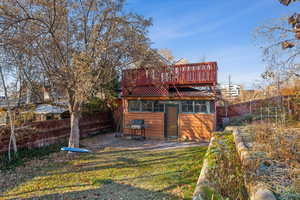 Back of property with a wooden deck and a lawn