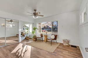 Living area featuring ceiling fan and wood-type flooring