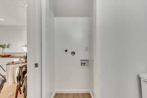 Laundry room with electric dryer hookup, light wood-type flooring, and hookup for a washing machine