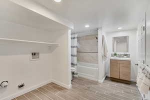 Full bathroom featuring shower / bath combination with curtain, toilet, and vanity