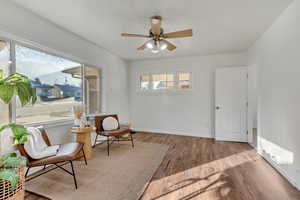 Living area with ceiling fan, plenty of natural light, and light hardwood / wood-style floors