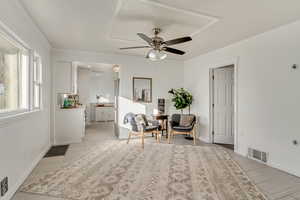 Sitting room featuring ceiling fan and ornamental molding