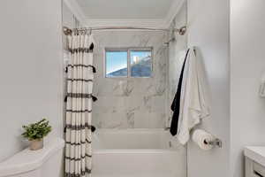 Bathroom featuring shower / bath combo, toilet, and crown molding