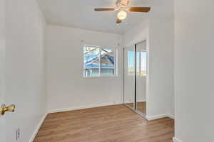 Unfurnished bedroom featuring light hardwood / wood-style floors, a closet, and ceiling fan