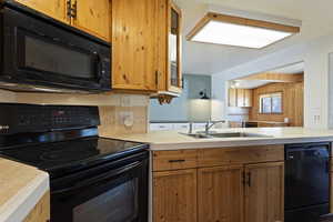 Kitchen with kitchen peninsula, sink, and black appliances