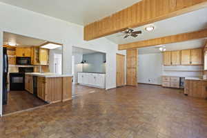 Kitchen with black appliances, ceiling fan, vaulted ceiling, and dark parquet floors