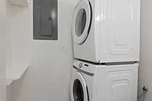 Clothes washing area with electric panel and stacked washer and clothes dryer