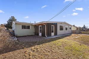 Rear view of property with a lawn and a patio area