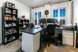 Home office with a textured ceiling and carpet floors