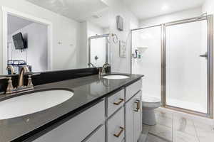 Bathroom featuring vanity, toilet, and an enclosed shower