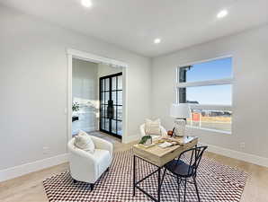 Office space with french doors and light hardwood / wood-style floors