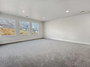 Carpeted spare room featuring a textured ceiling