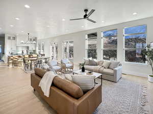 Living room featuring ceiling fan, light hardwood / wood-style flooring, and a textured ceiling