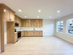 Kitchen with sink, light wood-type flooring, and stainless steel appliances