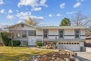 View of front of home featuring a front yard and a garage