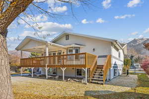 Rear view of house with a deck with mountain view and ceiling fan